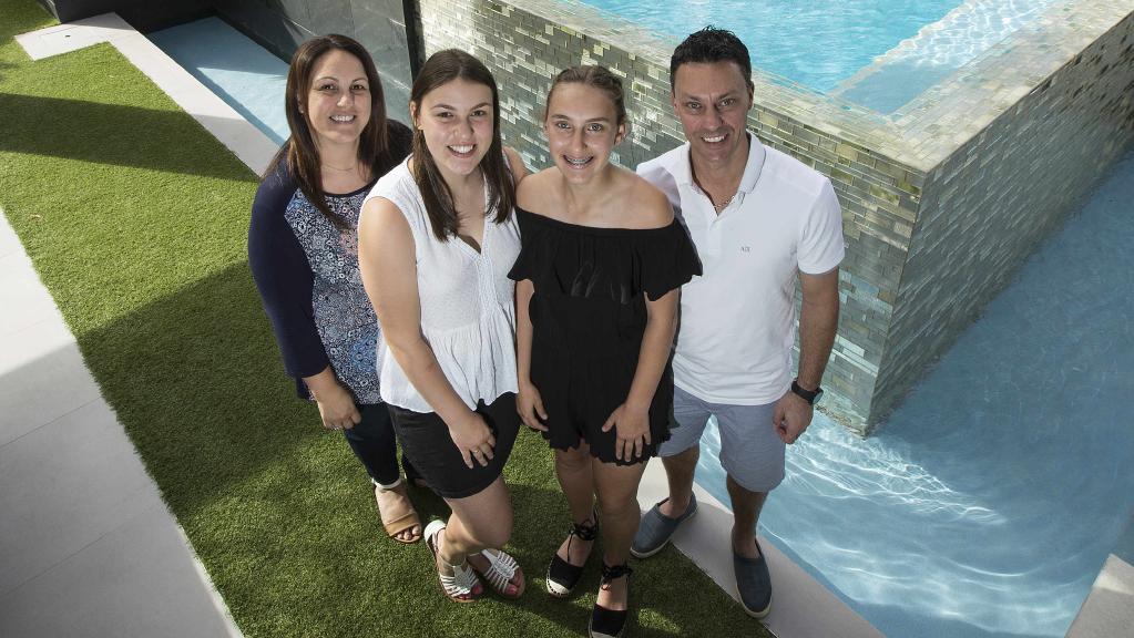 Daniela, Chiara, Alana and Daniel Scafetta outside their pool, which has a raised infinity waterwall. Picture: Will Russell