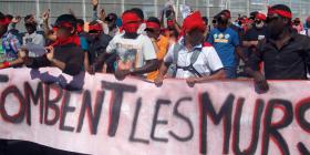 Migrants demonstrate, Calais: banner reads Tombent les murs [May the walls fall]