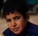 A Syrian boy displaced from eastern Aleppo holds a sandwich and bread bag in the village of Jibreen on Saturday.