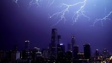 Lightning flashes above skyscrapers in Central Business District during a rainstorm in Beijing, Wednesday, Sept. 7, ...