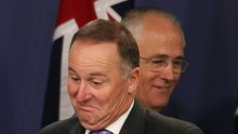 New Zealand Prime Minister John Key gestures as Prime Minister Malcolm Turnbull walks behind him