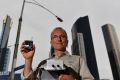 EPA expert Dr Anthony Boxshall holds a small air quality sensor, now installed on Queens Street Bridge lamps.