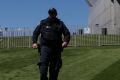 A security guard patrols the lawns at Parliament House.