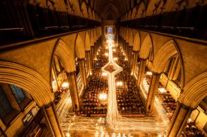 In this combination of two images the interior of Salisbury Cathedral is illuminated by trails of candles carried by ...