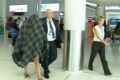 Police escort the accused transgender prostitute from Perth Airport.