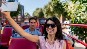 Portrait of a happy Asian woman taking a selfie on a tour bus in London - people traveling concepts. istock