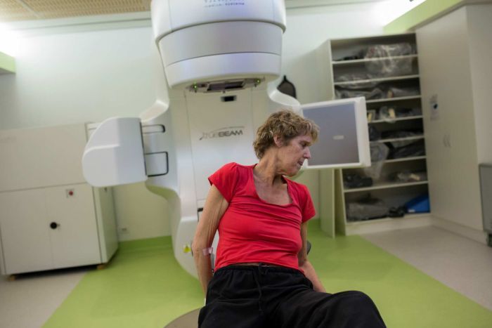 Sue Jensen lays herself out on the radiotherapy table for treatment.