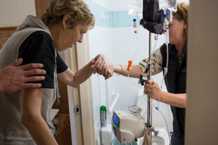 Sue's sister Robyn helps her into the hospital bathroom.