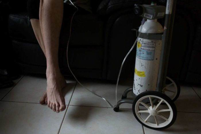 Sue Jensen's legs next to her oxygen bottle.