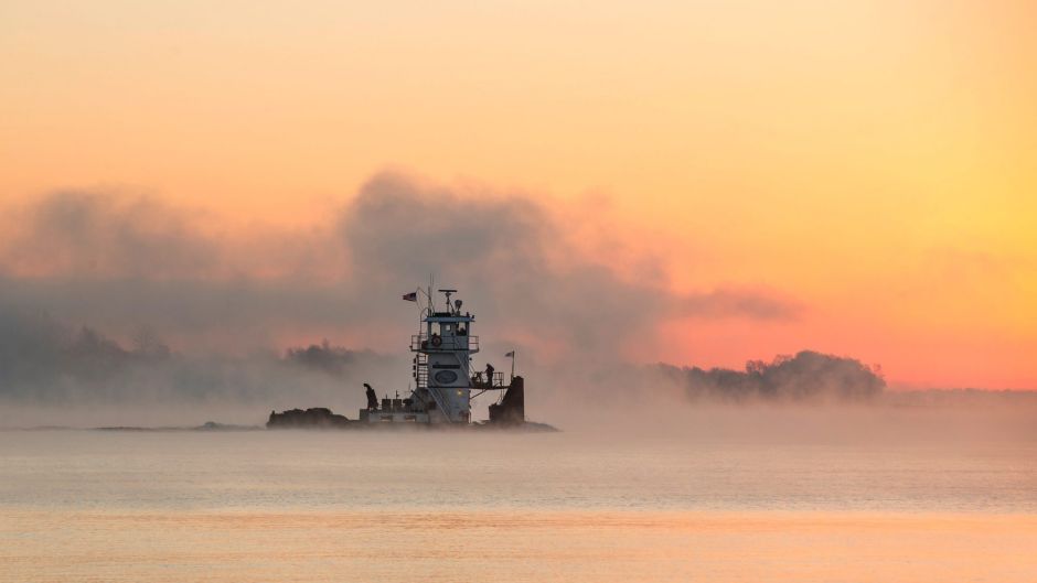 A tow boat travels along the Ohio River just before sunrise near Paducah.