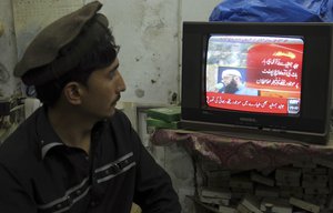 A Pakistani watches local news channel broadcasting report about a passenger plane taking off from Chitral, in the country's north, had crashed near a village near the town of Havelian, at his shop in Lahore, Pakistan, Wednesday, Dec. 7, 2016.