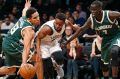 Thon Maker (right) applies the pressure as Bucks guard Malcolm Brogdon strips the ball from Nets guard Yogi Ferrell.