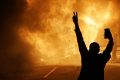 People watch as stores burn in Ferguson in November 2014 after the fatal police shooting of Michael Brown.