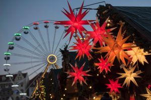 People walk in front of a stand decorated with Christmas stars during the Christmas Fair in Erfurt, central Germany, ...