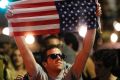 A man holds an American flag upside down as he stands with others in San Diego, to protest Donald Trump's presidential ...