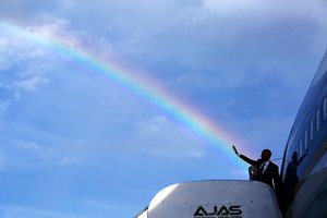 File - President Barack Obama's wave aligns with a rainbow as he boards Air Force One at Norman Manley International Airport prior to departure from Kingston, Jamaica, April 9, 2015.