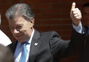 File - Colombia's President Juan Manuel Santos gives a thumb up to supporters after a press conference at the Santa Fe clinic in Bogota, Colombia, Monday, Nov. 21, 2016.