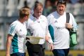 Struck: Paul Reiffel is helped from the field by England support staff.