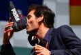 Webber drinks champagne from the boot of Daniel Ricciardo after the Belgium GP.