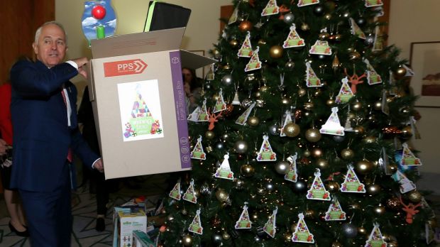 Prime Minister Malcolm Turnbull helps load the truck with christmas presents under the giving tree in his office at Parliament House in Canberra on 2 December 2016. fedpol Photo: Alex Ellinghausen