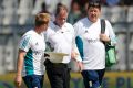 Reiffel, centre, is helped by the England team's support staff as he leaves the field for treatment.