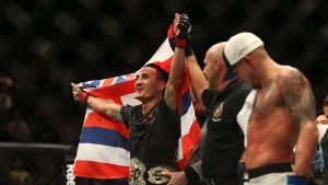 Belt up: Hawaiian Max Holloway celebrates his title win over America's Anthony Pettis.