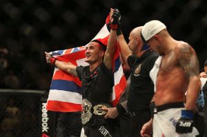 Belt up: Hawaiian Max Holloway celebrates his title win over America's Anthony Pettis.