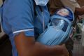 A newborn baby is transferred to an ambulance from a clinic in Anand, India, which has also banned surrogacy services ...