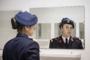 One of the youngest cadets taking part in the National Day parade checks her outfit in the mirror before departing to ...