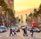 Pedestrians cross traffic on Hollywood Boulevard at dusk, Los Angeles.