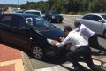 Opposition leader Mark McGowan, with Paul Papalia and Reece Whitby help out a woman in distress after her car broke down.