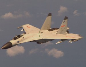 File - An armed Chinese fighter jet flies near a U.S. Navy P-8 Poseidon patrol aircraft over the South China Sea about 135 miles east of Hainan Island in international airspace.