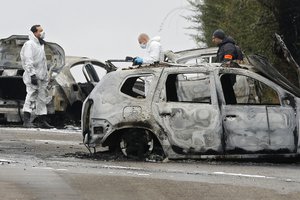 French police officers investigate on the highway where thieves rob an armored truck loaded with gold, Monday Dec. 12, 2016 in Dardilly, near Lyon, central France.