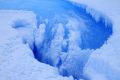 Moulin inside the crater on the Roi Baudouin ice shelf showing the drainage of meltwater.