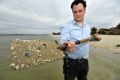 Michael Bourke with sand at Middle Park beach. Each grain of sand would host hundreds of micro-algae.  