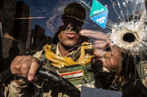 A Iraqi soldier of the 9th division sits at the wheel of a Humvee in Shyma district in Mosul, Iraq, on Tuesday, Dec. 6, ...