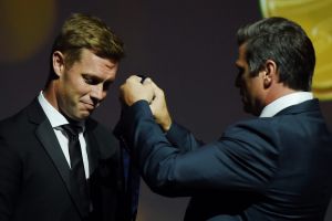 Former Hawthorn now West Coast player Sam Mitchell receives the 2012 Brownlow Medal from Shane Crawford on Tuesday. 
