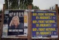 An election board with France's far-right Front National  leader, Marine Le Pen, and an anti-immigration poster.