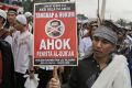 A protester holds a poster during a rally against Jakarta Governor Basuki "Ahok" Tjahaja Purnama, a Christian, over his ...