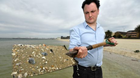 Michael Bourke with sand at Middle Park beach. Each grain of sand would host hundreds of micro-algae.  