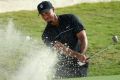 Comeback: Tiger Woods hits from a greenside bunker on the 14th during round one of the Hero World Challenge at Albany, ...