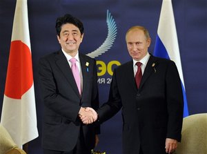 Russian President Vladimir Putin, right, and Japanese Prime Minister Shinzo Abe shake hands on the sidelines of the Asia-Pacific Economic Cooperation (APEC) forum in Bali, Indonesia, Monday, Oct. 7, 2013.