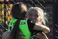 Karly Roestbakken embraces Nikky Flannery after the two youngest players on the pitch combine for the record-breaking win.