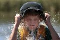 Chapman's Dylan Kirsten, 11, cools off in Lake Burley Griffin during the School Holiday Sailing School Tackers Program  ...