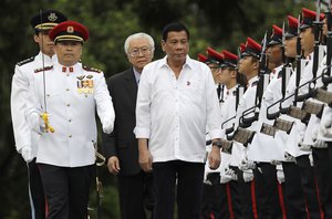 Philippine President Rodrigo Duterte, center front, is accompanied by Singapore's President Tony Tan, center back, as they inspect honor guards during a welcome ceremony at the Istana or presidential palace on Thursday, Dec. 15, 2016, in Singapore.