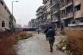 Syrian troops and pro-government gunmen marching through the streets of east Aleppo on Tuesday. 