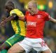 On song: Norwich City's Youssuf Mulumbu and Aaron Mooy battle for the ball at Carrow Road