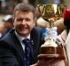  VRC chairman Michael Burn holds the Melbourne Cup.