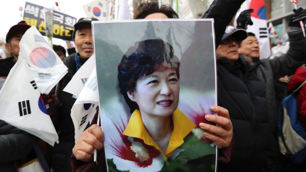 A supporter holds a portrait of South Korean President Park Geun-hye during a rally opposing her impeachment.