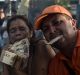 Demonstrators hold 100-bolivar banknotes while preparing food during the street protest in El Pinal.